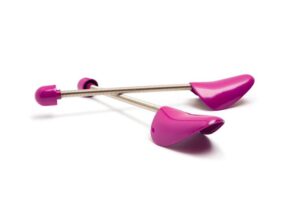 A pair of pink plastic spiral shoe trees with adjustable metal springs is shown against a white background, offering an effective alternative for maintaining shoe shape.