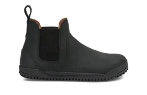 A black slip-on Chelsea Boot by Xero Shoes with elastic side panels, a pull tab at the back, rounded toe, and textured rubber sole. This simple design features visible stitching and a low heel—ideal for everyday styles.